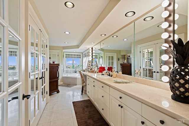 bathroom with tile patterned flooring, french doors, vanity, and a bathtub