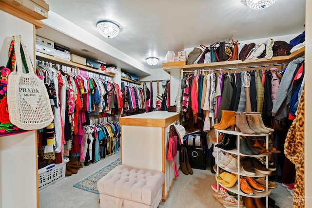 walk in closet featuring light colored carpet