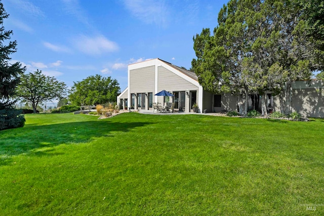 rear view of house featuring a patio and a lawn