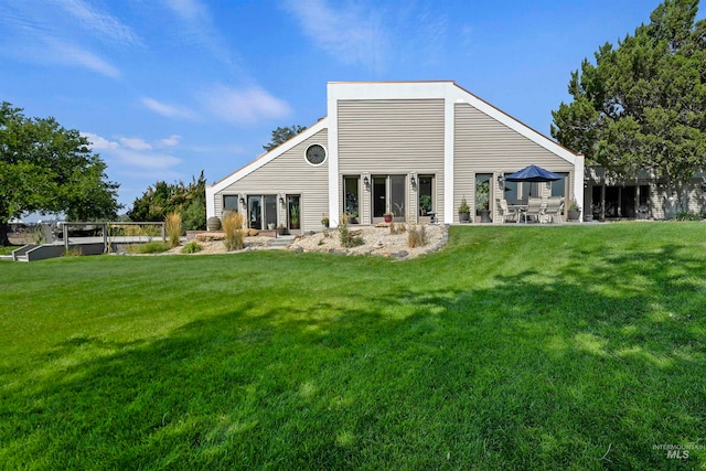 rear view of property featuring a yard and a patio