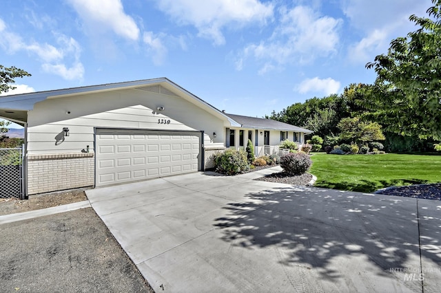 ranch-style home with brick siding, driveway, an attached garage, and a front yard