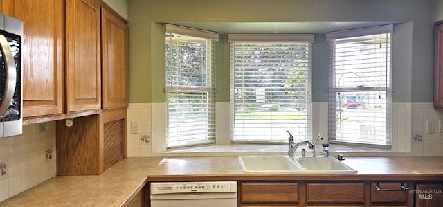 5720 N Oasis, Garden City, ID 83714 - kitchen featuring white dishwasher, a sink, brown cabinetry, and decorative backsplash
