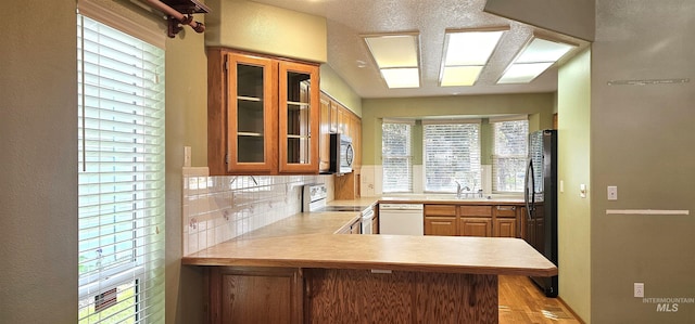 5720 N Oasis, Garden City, ID 83714 - kitchen with white appliances, light countertops, glass insert cabinets, a peninsula, and a sink