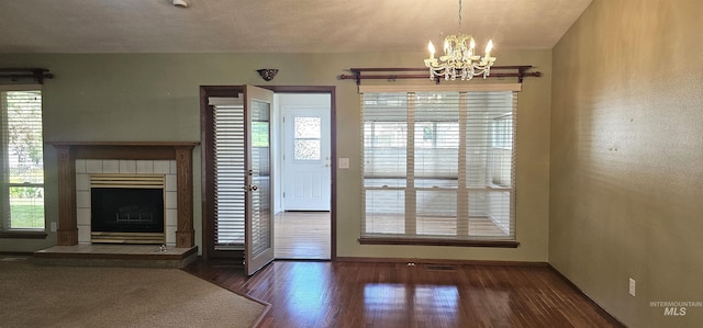 5720 N Oasis, Garden City, ID 83714 - unfurnished living room featuring a chandelier, baseboards, wood finished floors, and a fireplace