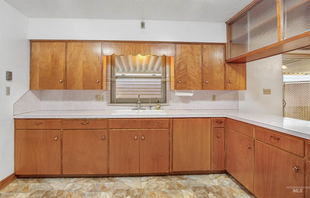 kitchen featuring a sink, open shelves, a wealth of natural light, and light countertops