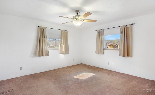 carpeted empty room featuring a ceiling fan