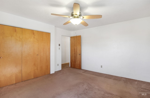 unfurnished bedroom featuring carpet, a ceiling fan, and a closet
