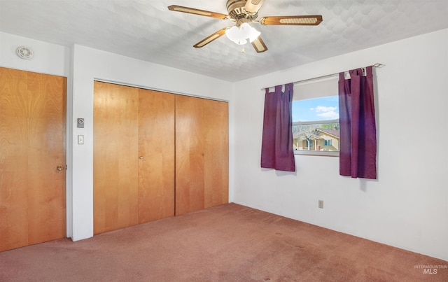 unfurnished bedroom with a closet, carpet flooring, and ceiling fan