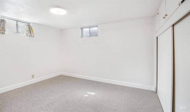 below grade area featuring baseboards and carpet
