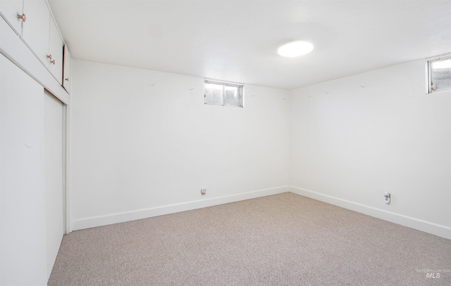 basement with light colored carpet and baseboards