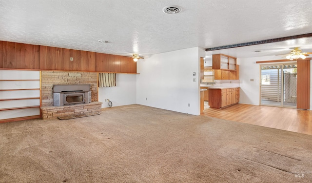 unfurnished living room with visible vents, a ceiling fan, a textured ceiling, and light colored carpet