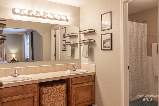 3929 N Shamrock Ave, Boise, ID 83713 - bathroom featuring double vanity, a shower with shower curtain, and backsplash