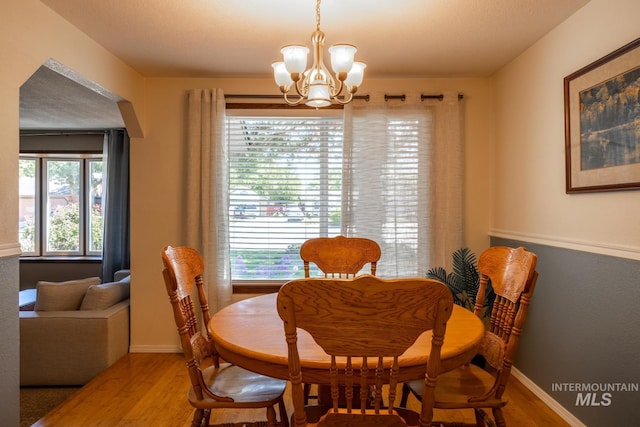 3929 N Shamrock Ave, Boise, ID 83713 - dining room featuring a chandelier, wood finished floors, and baseboards