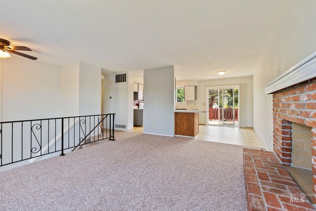 2045 11th Ave, Clarkston, WA 99403 - unfurnished living room featuring a ceiling fan, carpet flooring, a fireplace, a textured ceiling, and baseboards