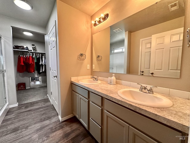 bathroom with hardwood / wood-style flooring, an enclosed shower, and vanity