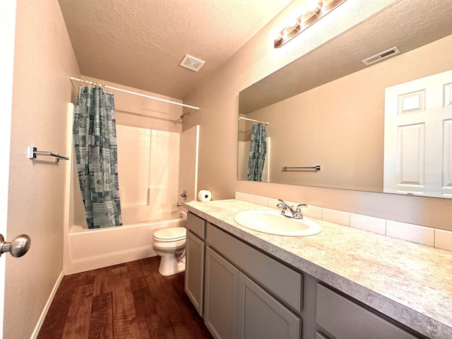 full bathroom with hardwood / wood-style floors, a textured ceiling, vanity, toilet, and shower / bath combo