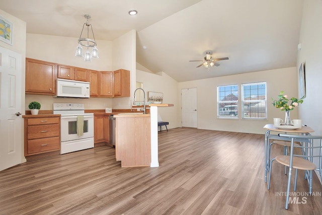 1522 Dana St, Twin Falls, ID 83301 - kitchen featuring white appliances, a peninsula, open floor plan, ceiling fan, and light wood-style flooring
