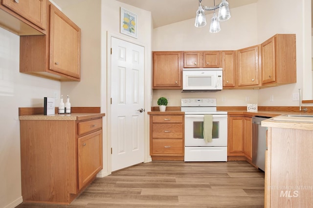 1522 Dana St, Twin Falls, ID 83301 - kitchen featuring white appliances, light wood finished floors, vaulted ceiling, light countertops, and pendant lighting