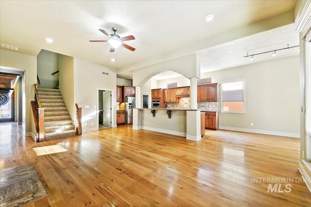 unfurnished living room featuring light hardwood / wood-style flooring and ceiling fan