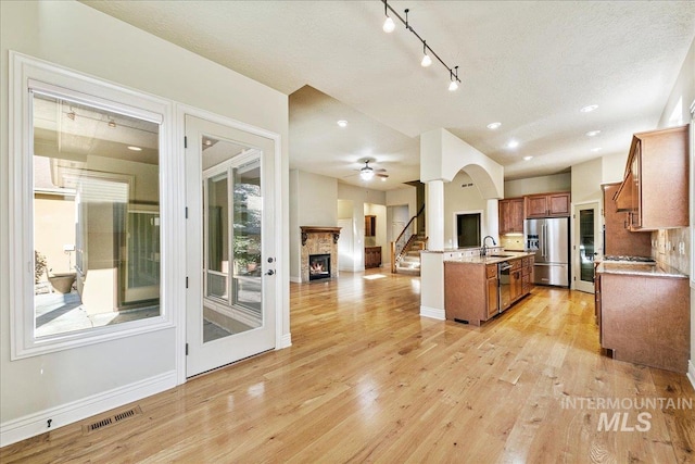 kitchen featuring appliances with stainless steel finishes, light hardwood / wood-style flooring, plenty of natural light, and sink