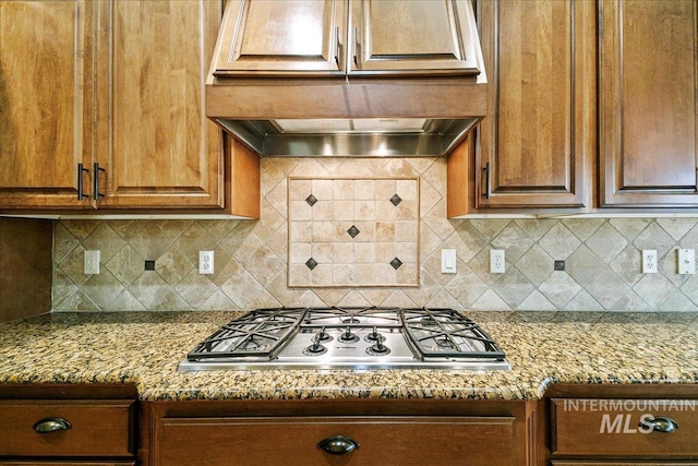 kitchen featuring decorative backsplash, light stone countertops, and stainless steel gas cooktop