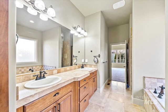 bathroom featuring tiled bath, tile patterned flooring, and vanity