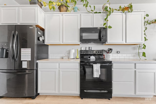 2318 Oxon St, Caldwell, ID 83605 - kitchen featuring black appliances, light countertops, white cabinetry, and light wood-style flooring