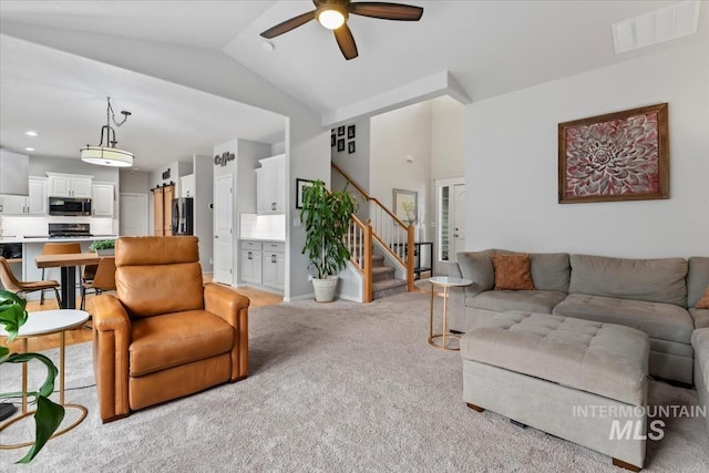 10450 W Antietam St, Boise, ID 83709 - living area with a ceiling fan, light colored carpet, visible vents, lofted ceiling, and stairs