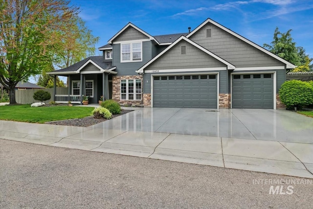 10450 W Antietam St, Boise, ID 83709 - craftsman house with a porch, a front yard, concrete driveway, an attached garage, and stone siding
