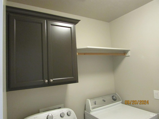 washroom featuring cabinets and separate washer and dryer