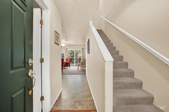 entrance foyer with baseboards and stairway