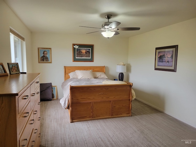 bedroom with light colored carpet, baseboards, and ceiling fan