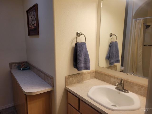 bathroom with curtained shower and vanity