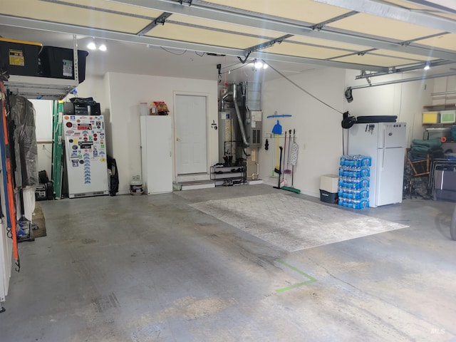 garage featuring refrigerator, heating unit, water heater, and freestanding refrigerator