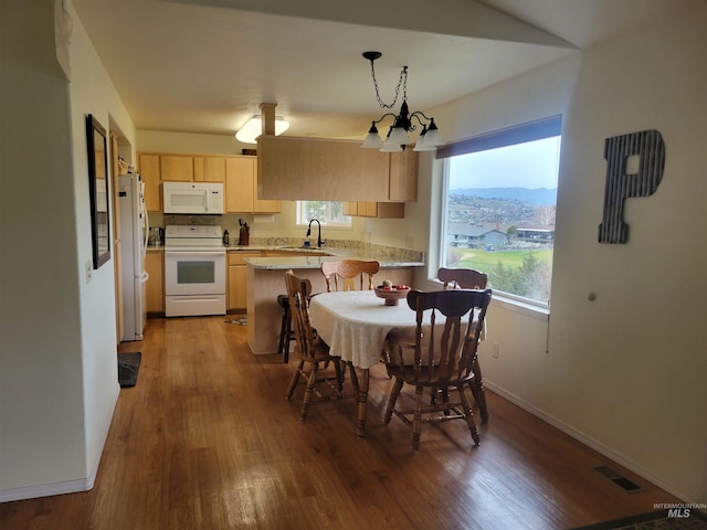 dining space with wood finished floors, visible vents, and baseboards