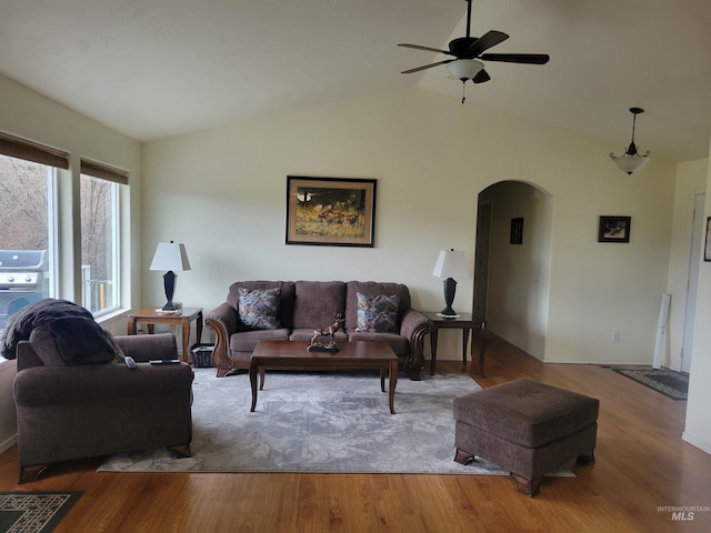 living room with arched walkways, vaulted ceiling, ceiling fan, and wood finished floors