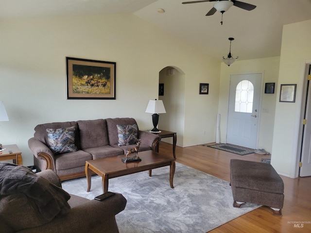 living area with ceiling fan, lofted ceiling, arched walkways, and wood finished floors