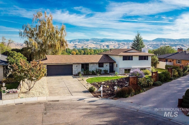 5696 N Kriscliffe, Boise, ID 83704 - split level home featuring a mountain view, a garage, driveway, stone siding, and a chimney