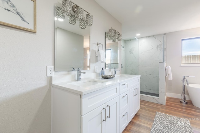5696 N Kriscliffe, Boise, ID 83704 - bathroom featuring a marble finish shower, double vanity, a freestanding bath, wood finished floors, and baseboards