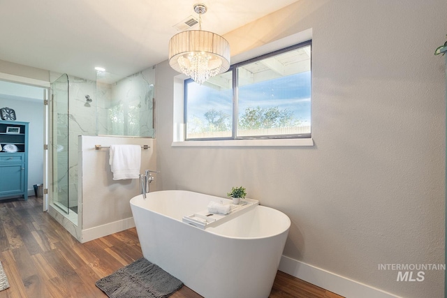 5696 N Kriscliffe, Boise, ID 83704 - full bath featuring a soaking tub, a marble finish shower, wood finished floors, a chandelier, and baseboards