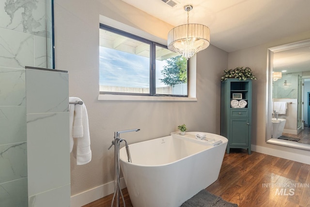 5696 N Kriscliffe, Boise, ID 83704 - full bathroom featuring a freestanding tub, wood finished floors, a chandelier, and baseboards