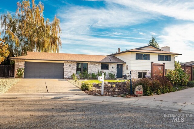 5696 N Kriscliffe, Boise, ID 83704 - tri-level home featuring stone siding, a garage, and concrete driveway