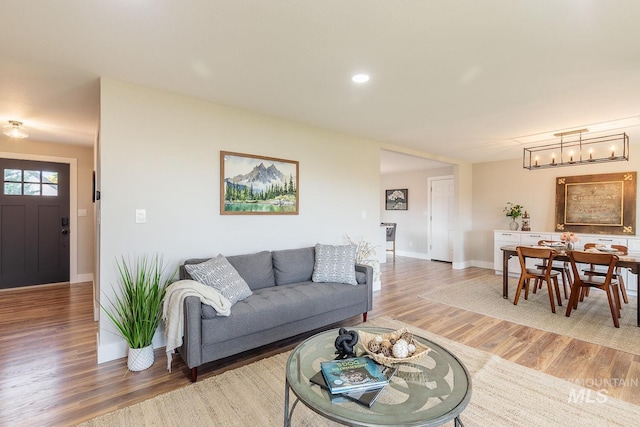 5696 N Kriscliffe, Boise, ID 83704 - living room with light wood finished floors, a chandelier, and baseboards
