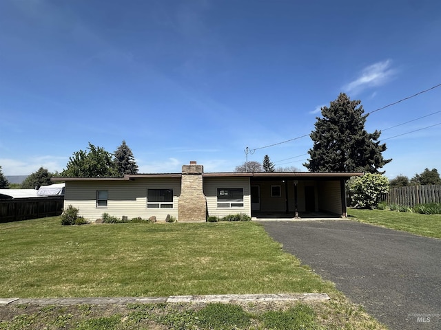 single story home featuring aphalt driveway, fence, a front yard, and a chimney