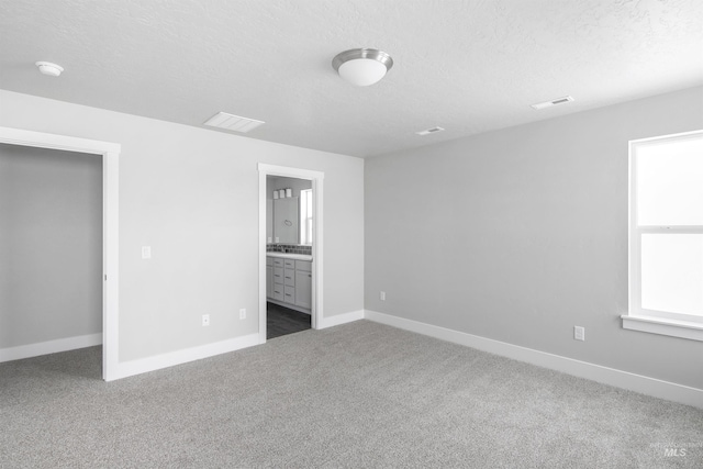 unfurnished bedroom featuring baseboards, a textured ceiling, visible vents, and carpet flooring