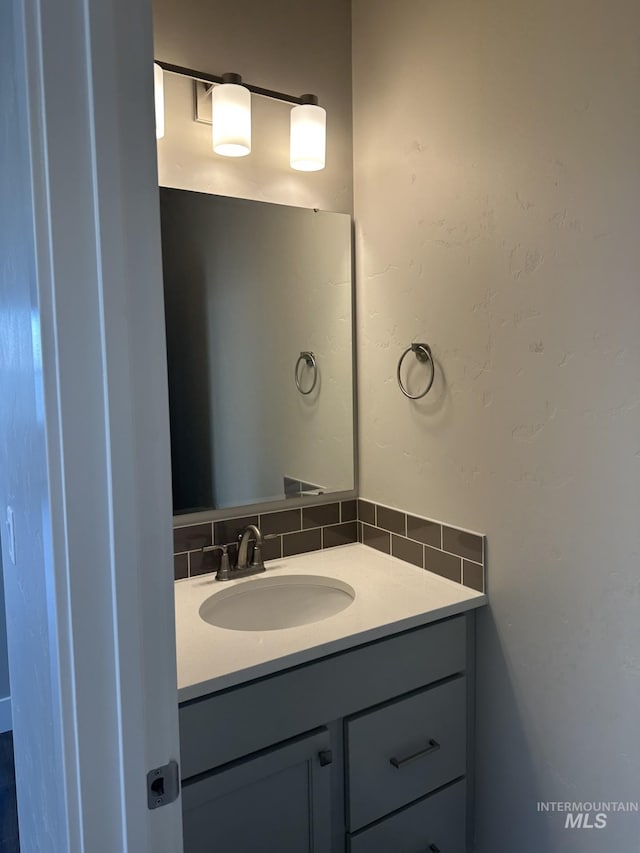 bathroom featuring vanity and backsplash