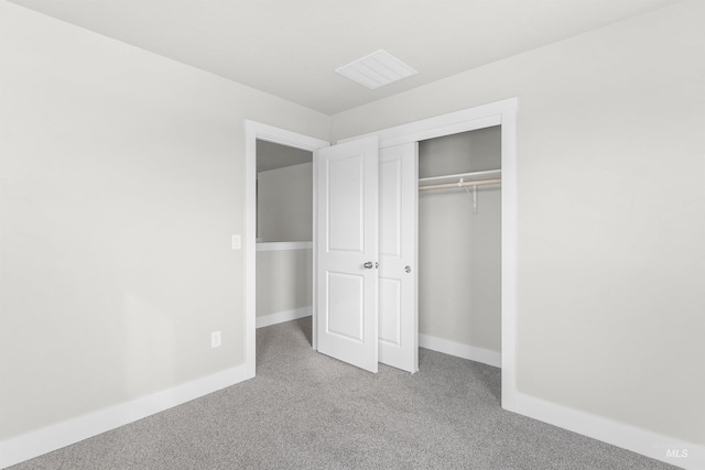 unfurnished bedroom featuring a closet, carpet flooring, visible vents, and baseboards