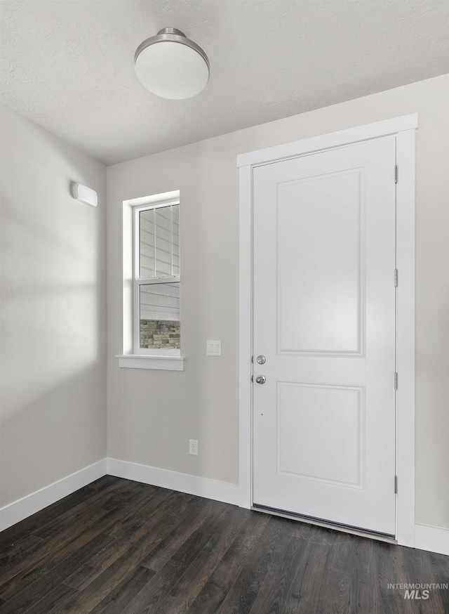 entryway with dark wood-style flooring and baseboards