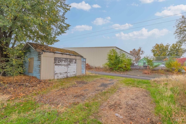 view of yard featuring a garage and an outbuilding