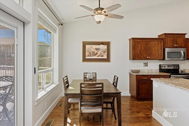 dining room with visible vents, lofted ceiling, dark wood-type flooring, and baseboards